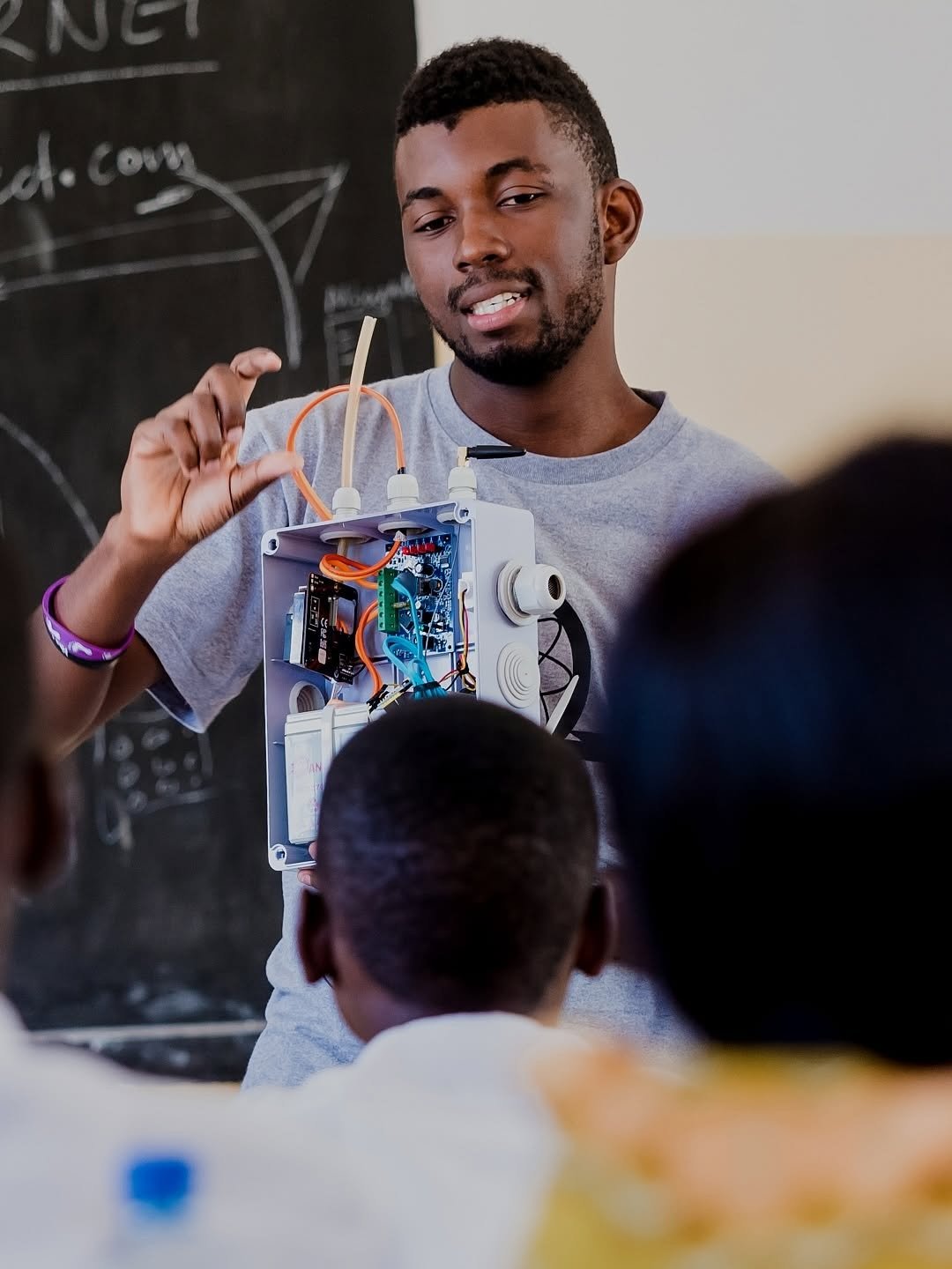 A teacher showing students a low-cost air quality sensor