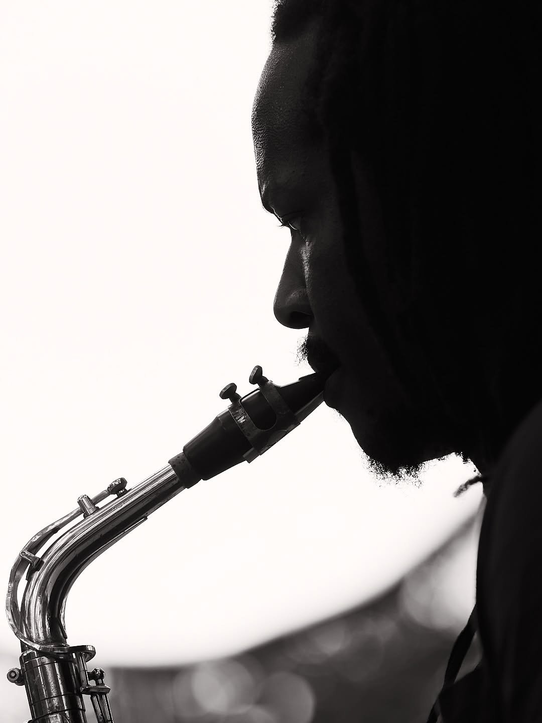 Silhouette of a saxophone player against a white background
