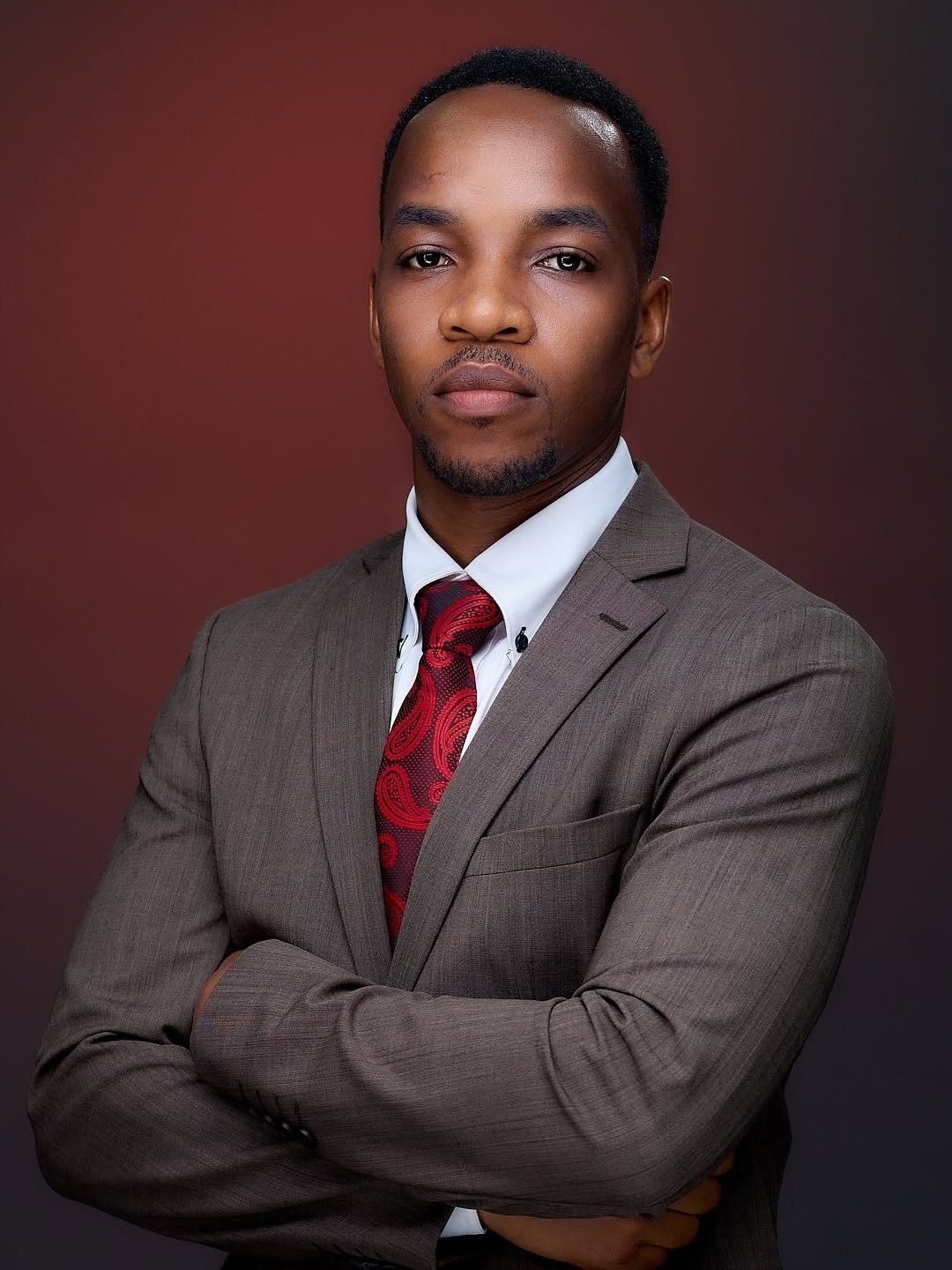 Portrait of a man in a suit against a red background
