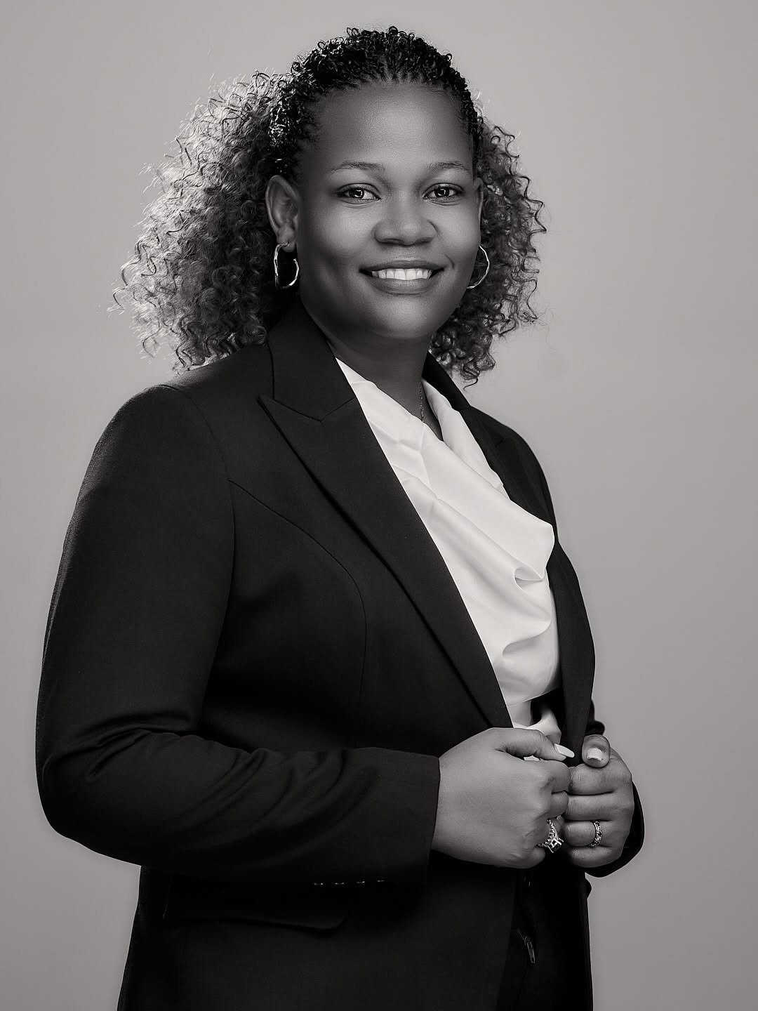 Black and white portrait of a smiling woman in a dark blazer
